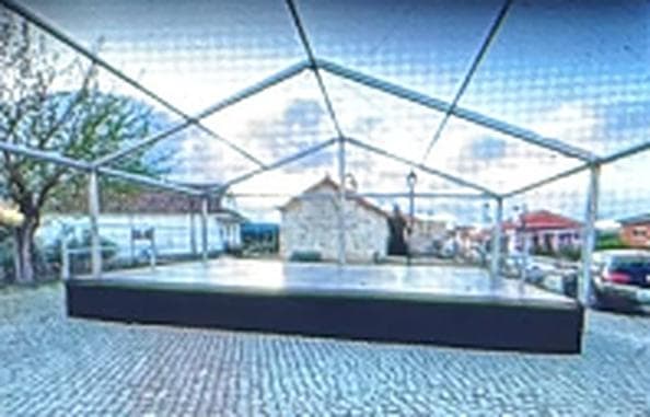 Estrado técnico sob estrutura metálica de tenda numa praça de calçada